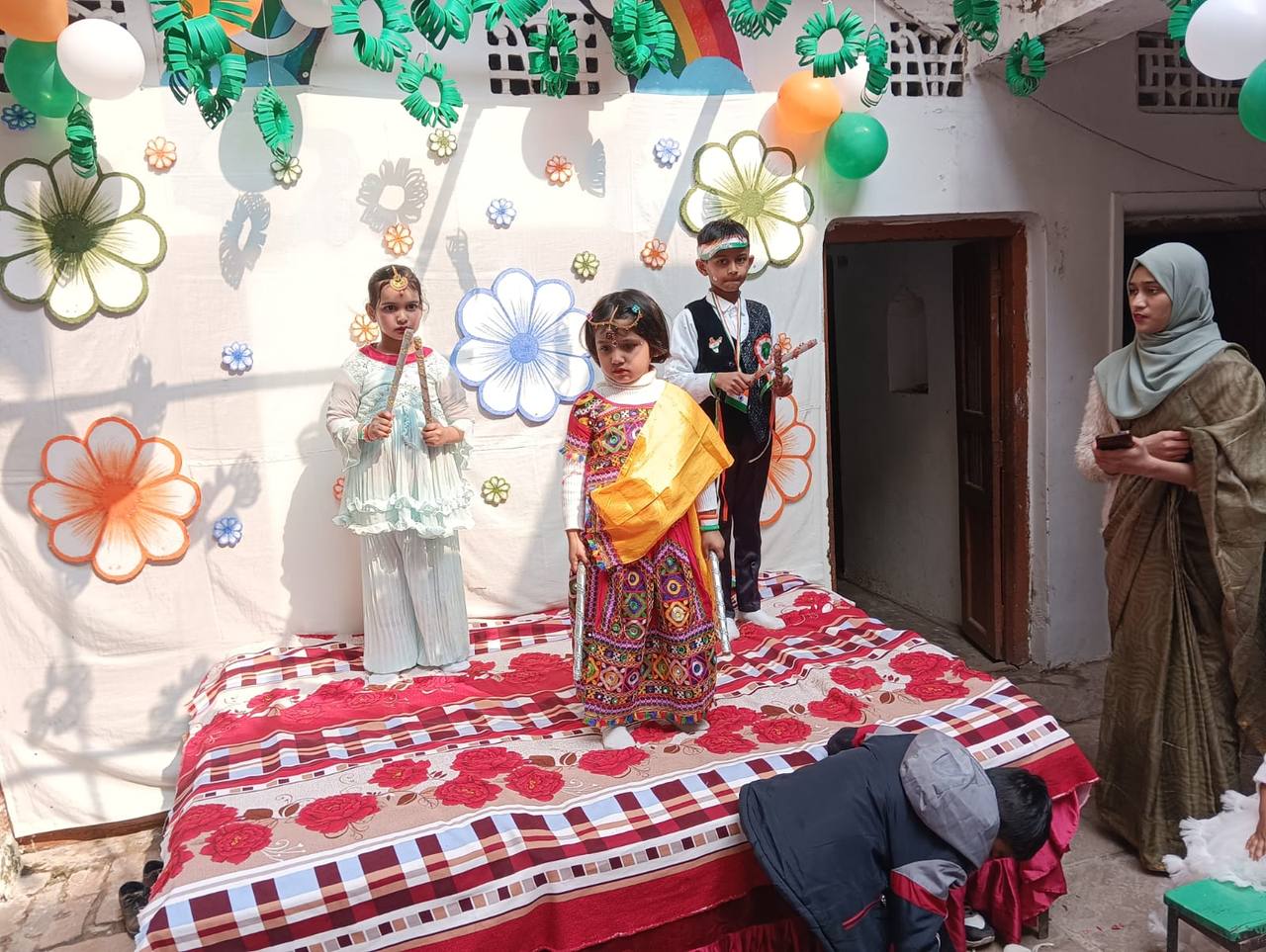 Students performing a folk dance on stage for Independence Day